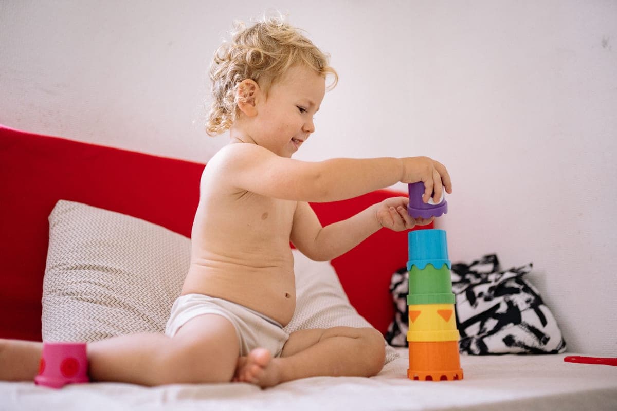 A toddler playing with large soft stacking blocks