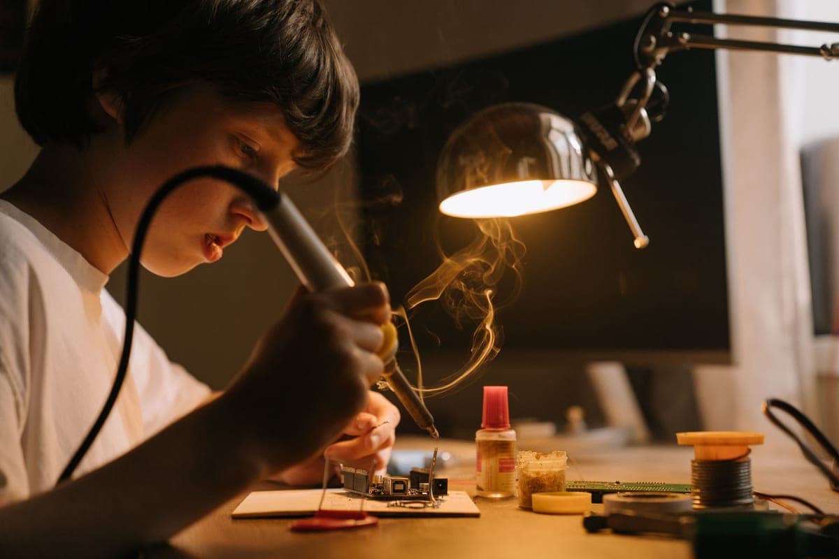 An older child working on an electronics project at a desk