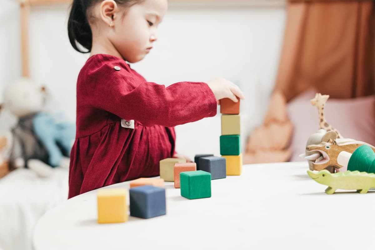 A young child building a tall block tower