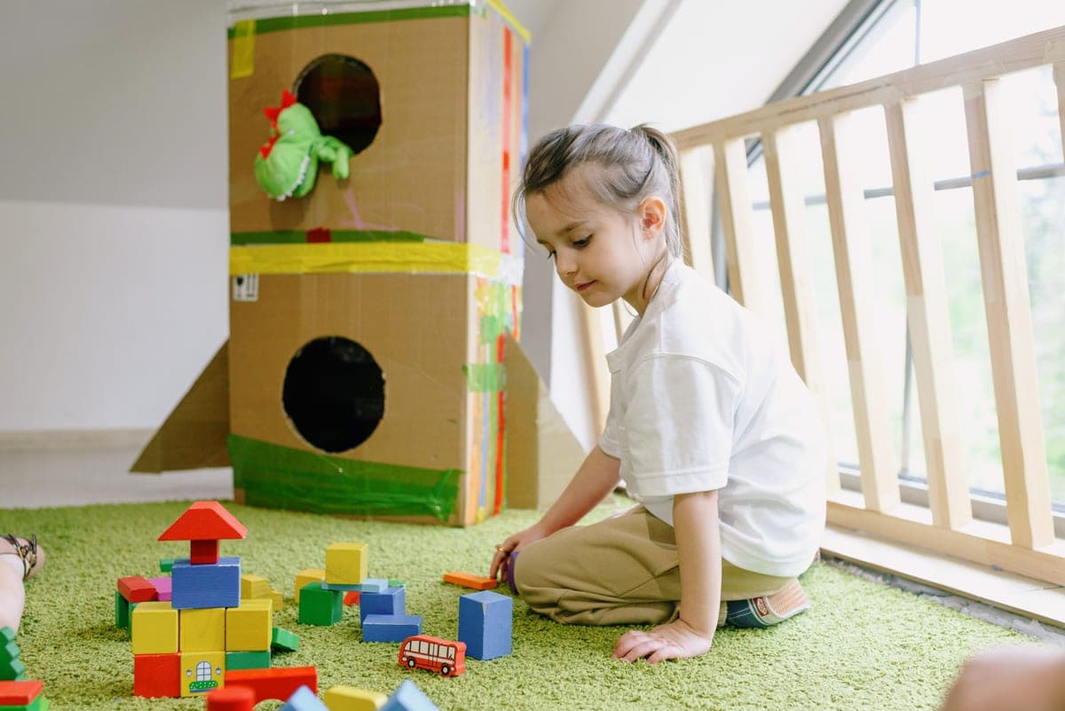 A kindergarten-age child building with construction toys