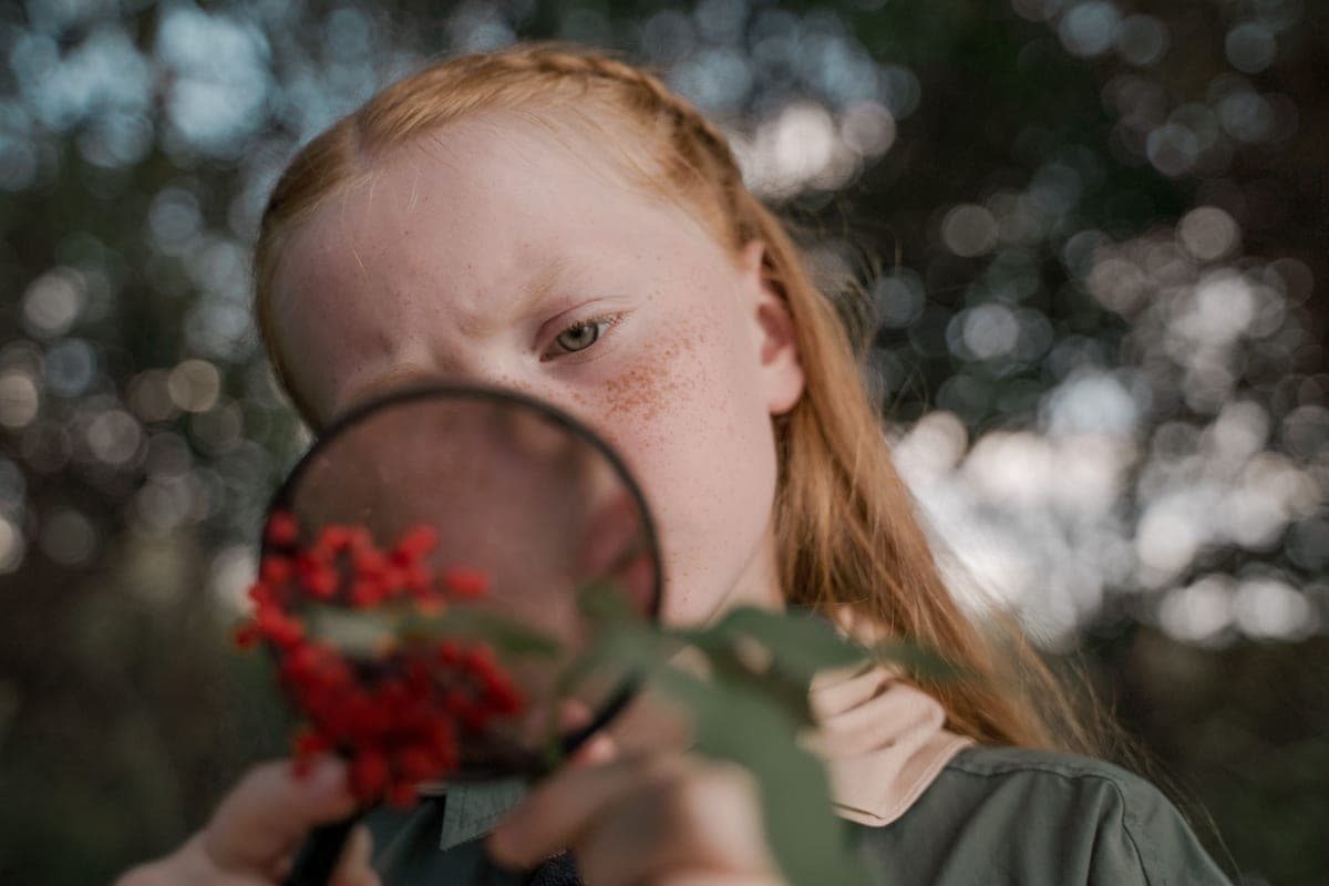 A child using a magnifying glass to examine nature