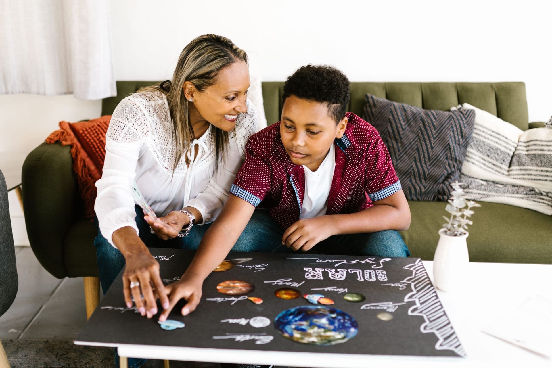 A mother and son working on a solar system project at home