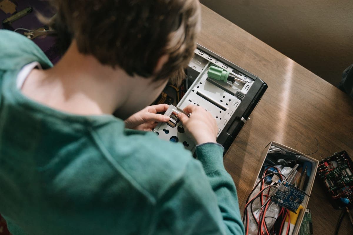 A teenager assembling electronics and a circuit board