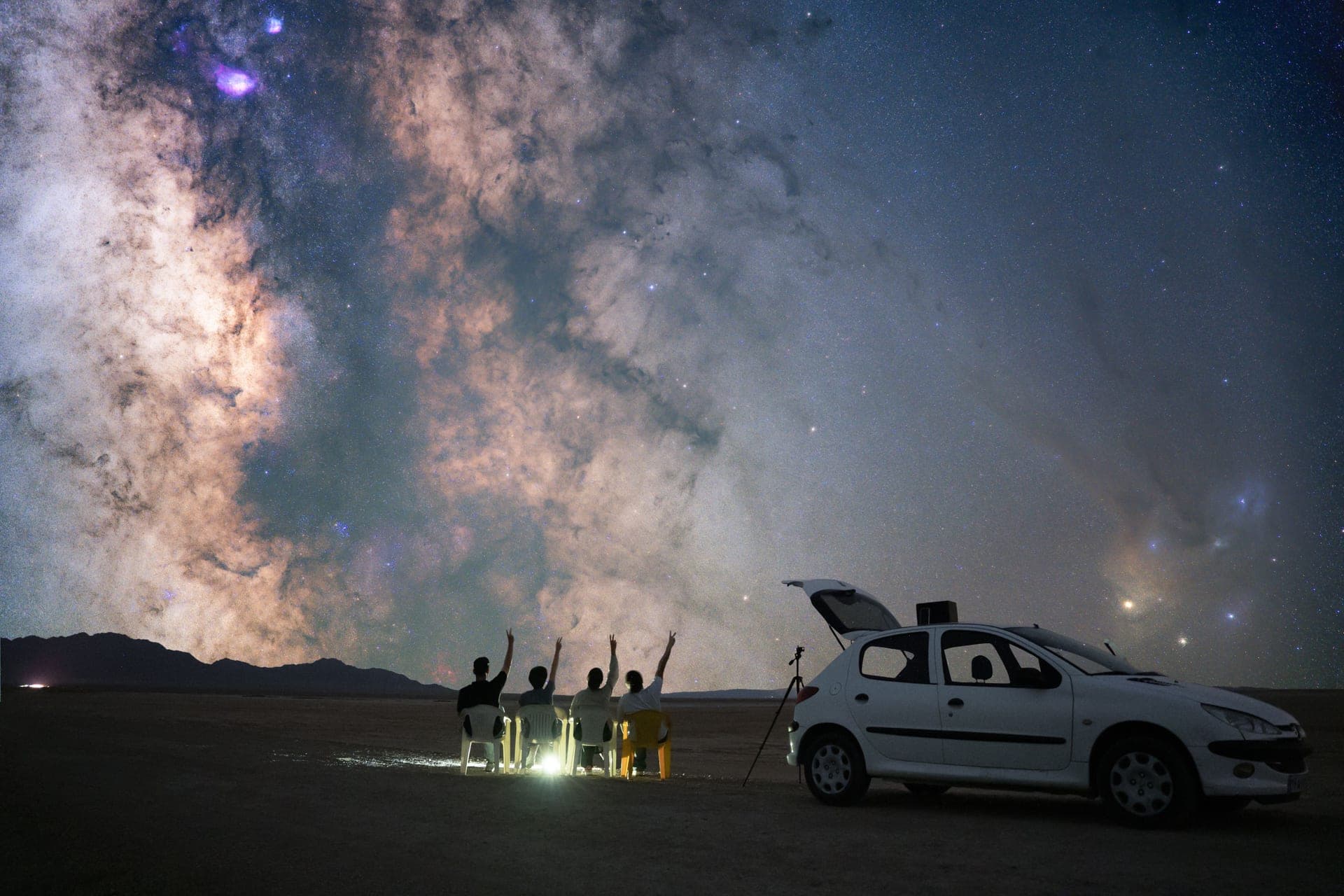 A telescope and smartphone under a night sky