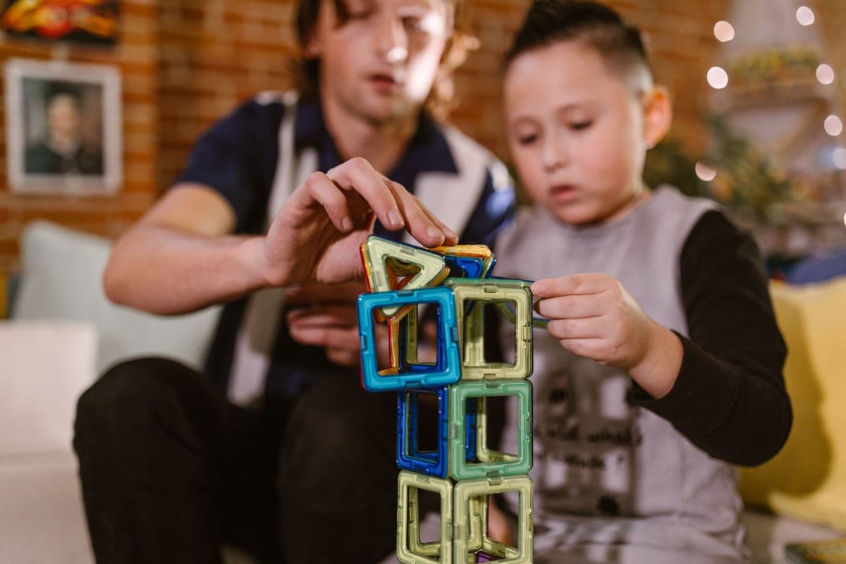 A child building a castle from colorful magnetic tiles