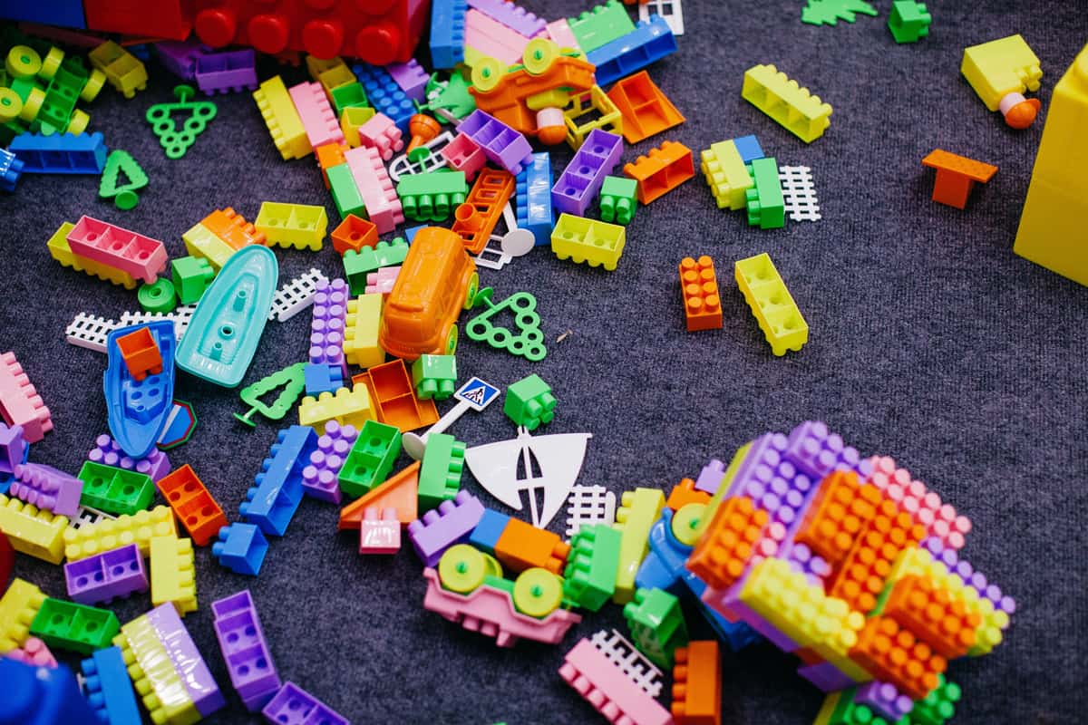 Plastic building bricks and colorful tiles side by side